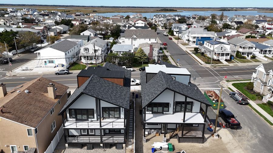 Aerial view of the two Wildwood Crest homes with the neighborhood and bay behind them