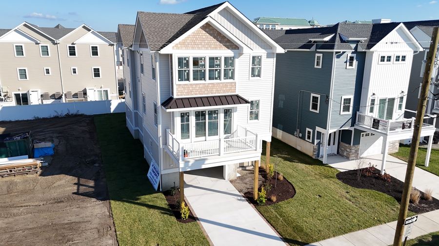 Front of a new three-story home in North Wildwood with a covered balcony and fresh lawn