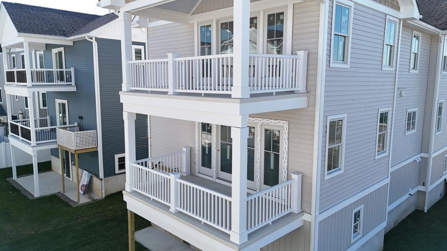 Close aerial view of stacked white balconies on a new North Wildwood home