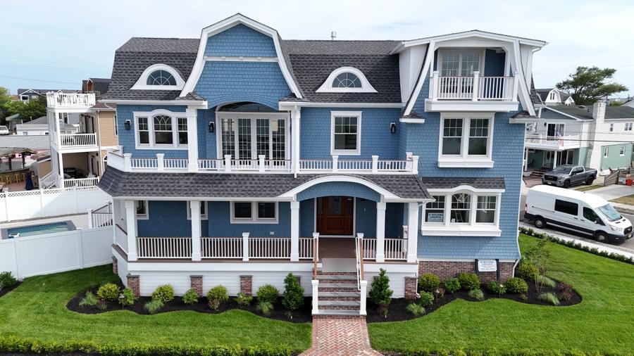 Front of a blue gambrel-roof home in Wildwood Crest with a wraparound porch